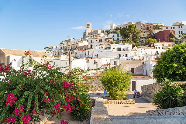 Whitewashed Ibiza village with flowers and hillside houses
