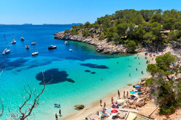 Turquoise Ibiza cove with boats and a sheltered beach